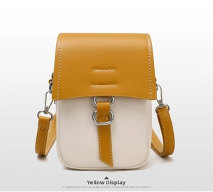 Detail of yellow and beige contrast mini crossbody phone bag with silver metal hooks