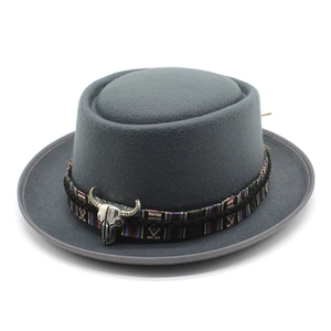 Detail of wool pork pie hat featuring ethnic woven band and silver bull head ornament