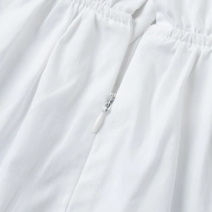 Detail of hidden zipper and elastic pleated stitching on a white high-neck shirt