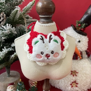 Close-up of reindeer plush bib for pets with red and white knit festive textures