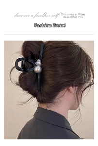 Detail showing a large black hair claw clip with grey pearl and rhinestone heart on hair