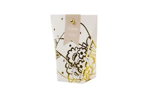 Detailed close-up of gold floral stamping and thank you tag on wedding gift bag