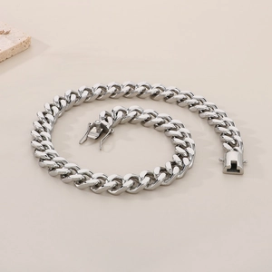 Macro shot of a 13mm silver stainless steel Cuban link necklace with secure clasp