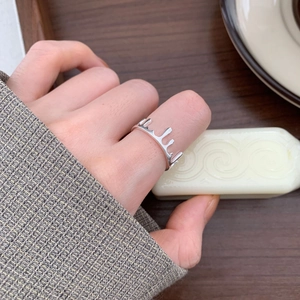 Minimalist 925 sterling silver liquid lava crown ring worn on hand with wood background
