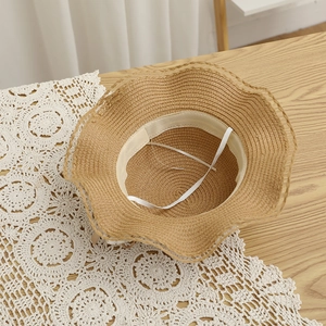 Détail du chapeau de paille festonné montrant la bande de confort et le cordon réglable