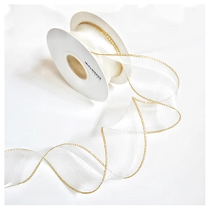 Detail of sheer champagne ribbon with gold metallic edges on a professional spool
