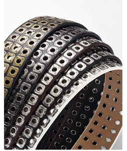 Detailed view of multi-color punk PU leather belts with triple-row square grommets