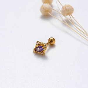 Dettaglio ravvicinato di orecchino in oro con pietra marquise viola e zirconi bianchi