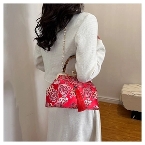 Detailed view of red Chinese style handbag featuring bamboo handle and elegant silk tassel