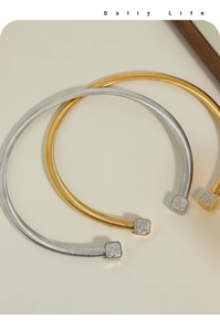 Détail de ras-de-cou spirale or et argent avec pendentifs carrés en strass pavés