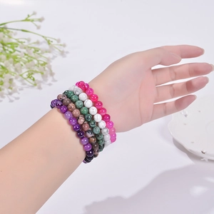 Close-up of stacked 8mm natural stone beaded bracelets with colorful zebra jasper textures