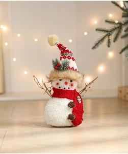 Detailed view of snowman plush with red scarf, pine cones and rustic branch arms decoration