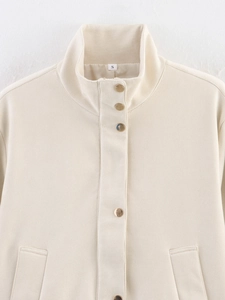 Detail view of cream faux suede jacket showing the stand collar and golden metal buttons