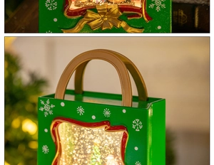 Macro detail of a green Christmas lantern music box with snow scene and golden handle