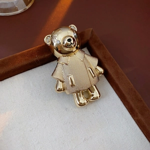 Detail einer goldenen Bärenbrosche mit Strasssteinen auf einem Stoff-Display-Tablett