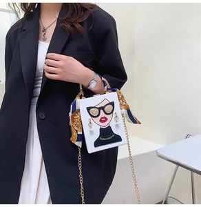 Detail view of white box evening bag with unique graphic print and gold chain strap