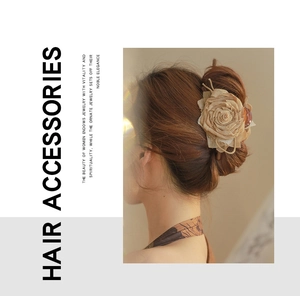 Detailed close-up of handmade fabric rose hair claw in elegant champagne beige color