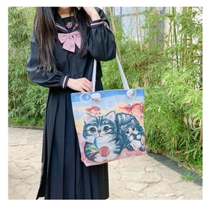 Detail view of large jacquard canvas tote bag with cat and goldfish pattern design