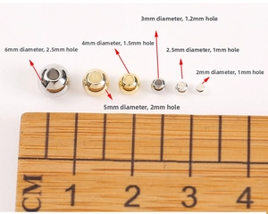 Size comparison of 18K gold-plated spacer beads with a ruler showing various diameters