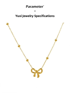 Detail of 18K gold butterfly bow pendant and star bead chain on titanium necklace