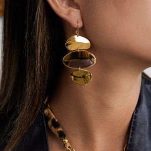 Gros plan sur des boucles d'oreilles ovales irrégulières dorées à trois couches