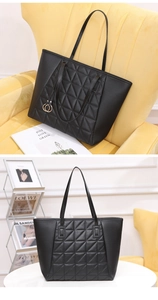 Close-up of black quilted tote bag with diamond stitching and metal ring pendant