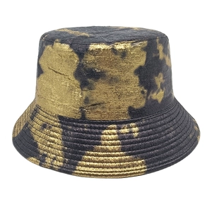 Detailed view of the double-sided bucket hat with black and gold tie-dye metallic texture