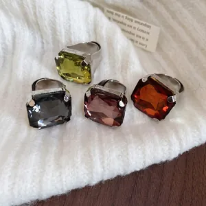 Retro square gemstone rings with crystal accents on a soft white knit background