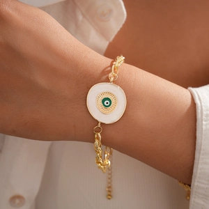 Gros plan du bracelet chaîne en or avec pendentif Nazar œil grec sur le poignet