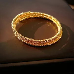 Bracelet spirale luxueux à plusieurs rangées de perles dorées avec finition métallique