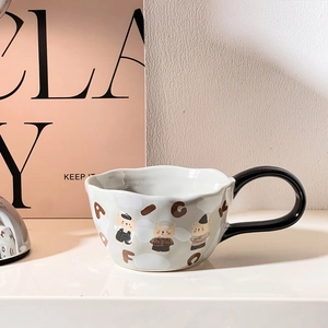 Detail of cute cartoon bear patterns and black solid handle on a ceramic mug