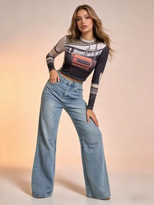 Detail of light blue wide-leg jeans paired with a cropped printed long-sleeve top