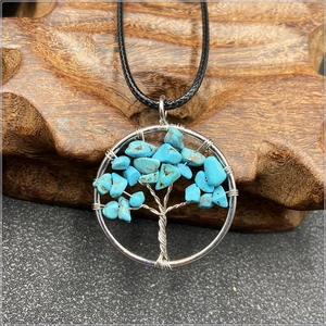 Macro detail of silver tree of life pendant featuring natural turquoise stone chips
