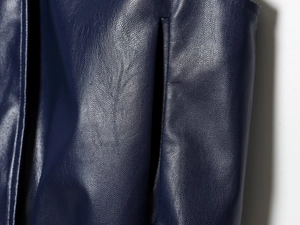 Detailed close-up showing pocket stitching and dark blue leather texture of the skirt