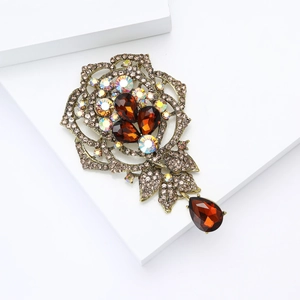 Detailed view of rose flower brooch with bronze metal and amber teardrop rhinestone