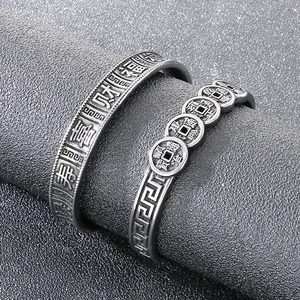 Detail of vintage steel cuff bracelet with embossed Chinese lucky characters and coins