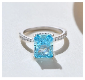 Macro shot of Radiant-cut blue gemstone ring with pave diamonds on S925 silver band