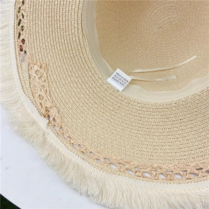 Dettaglio della trama in paglia e etichetta 100% carta su un cappello a tesa larga