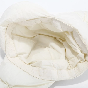 Detail view of white winter hat interior showing precise quilting and windproof fabric
