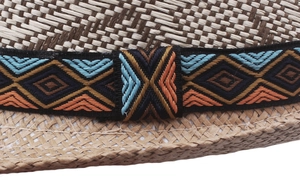 Close-up of light beige straw hat with detailed geometric ethnic ribbon weaving