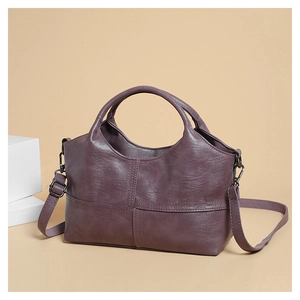 Detail of soft purple leather texture with cross-stitch design and adjustable shoulder strap