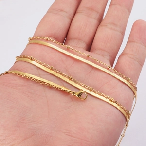 Double layered gold snake and bead chain necklace in stainless steel shown on hand