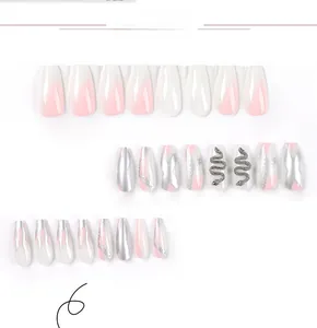 Detail of pink ombre press-on nails with silver flame patterns and 3D snake charms