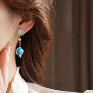 Detail view of goldfish pattern inside blue glass bead on summer starfish earrings