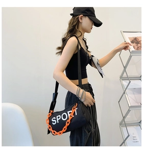 Détail du sac bandoulière sport en nylon noir avec chaîne orange vif et logo sport