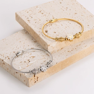 Elastic stainless steel wire bracelets with clover charms in gold and silver finish