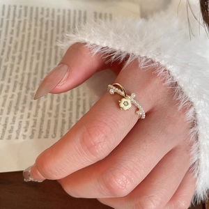 Détail de la bague fleur de marguerite plaquée or 14 carats avec perles et émail sur main