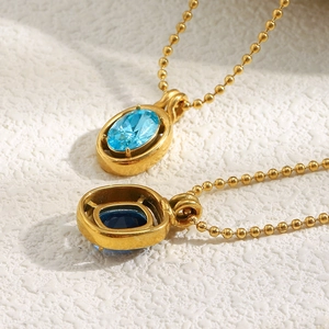 Detail of 18K gold-plated beaded chains with square and oval blue zircon pendants