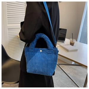 Detailed close-up of blue corduroy texture on a mini crossbody bag with vertical ribbing