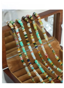Detail of colorful beads and gold spacers on a beaded necklace in a wood jewelry box